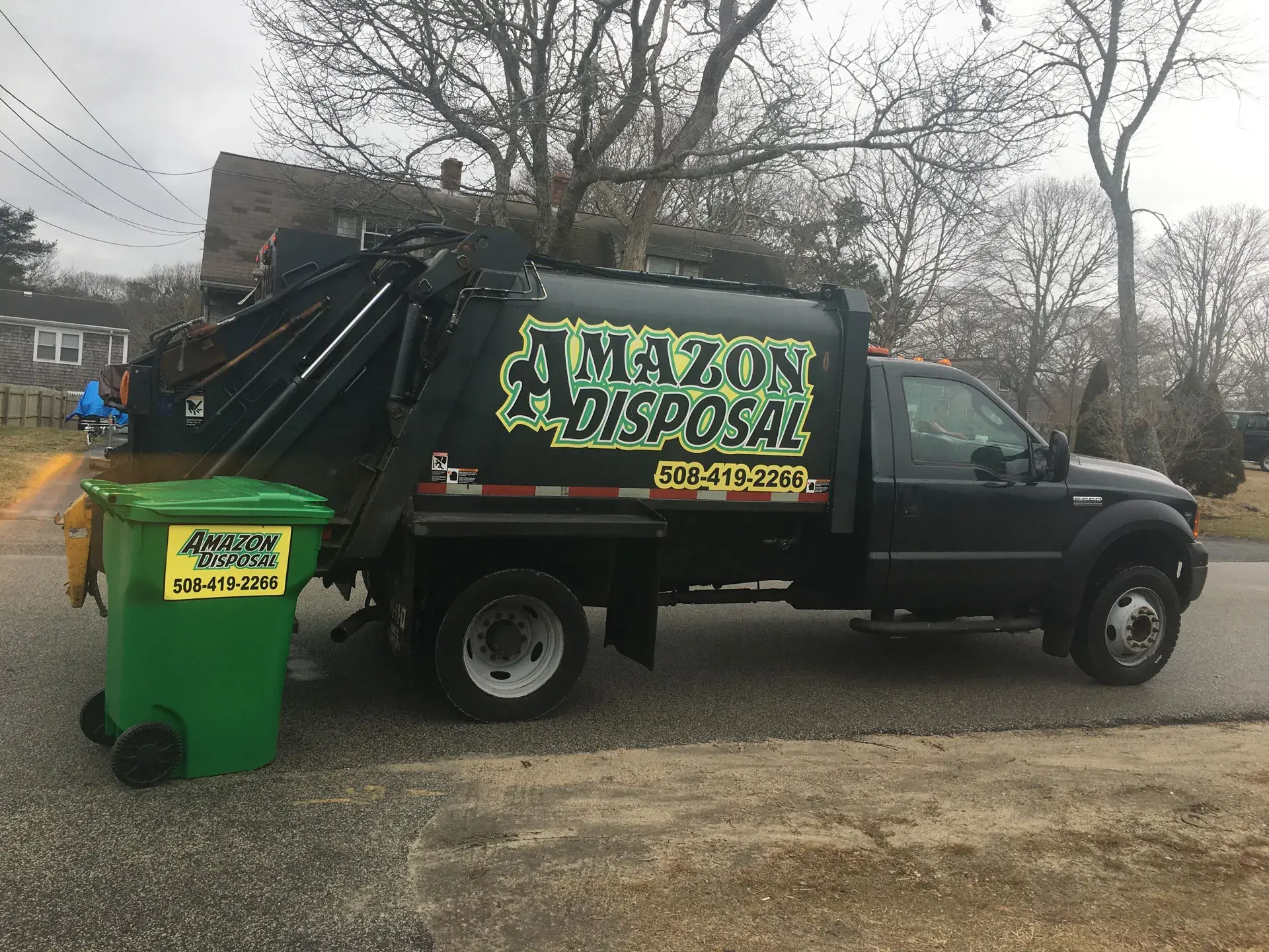 Amazon Disposal truck and green 95-gallon tote on a Cape Cod street